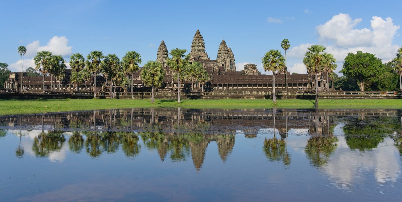 Angkor Wat's iconic five lotus-bud towers reflected in the surrounding moat at sunrise