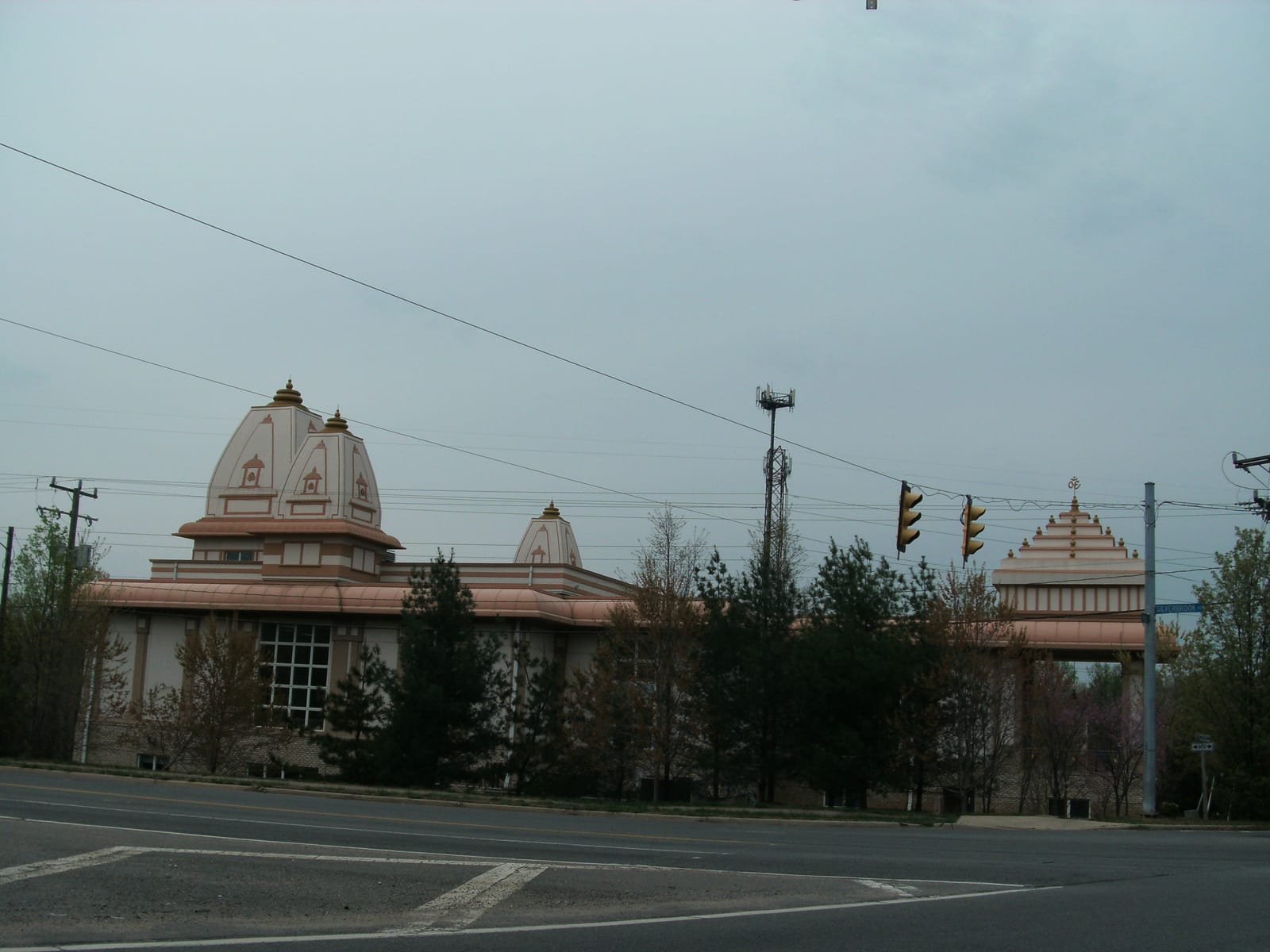 The white shikhara of Vishnu Devi Mandir against a suburban Virginia sky